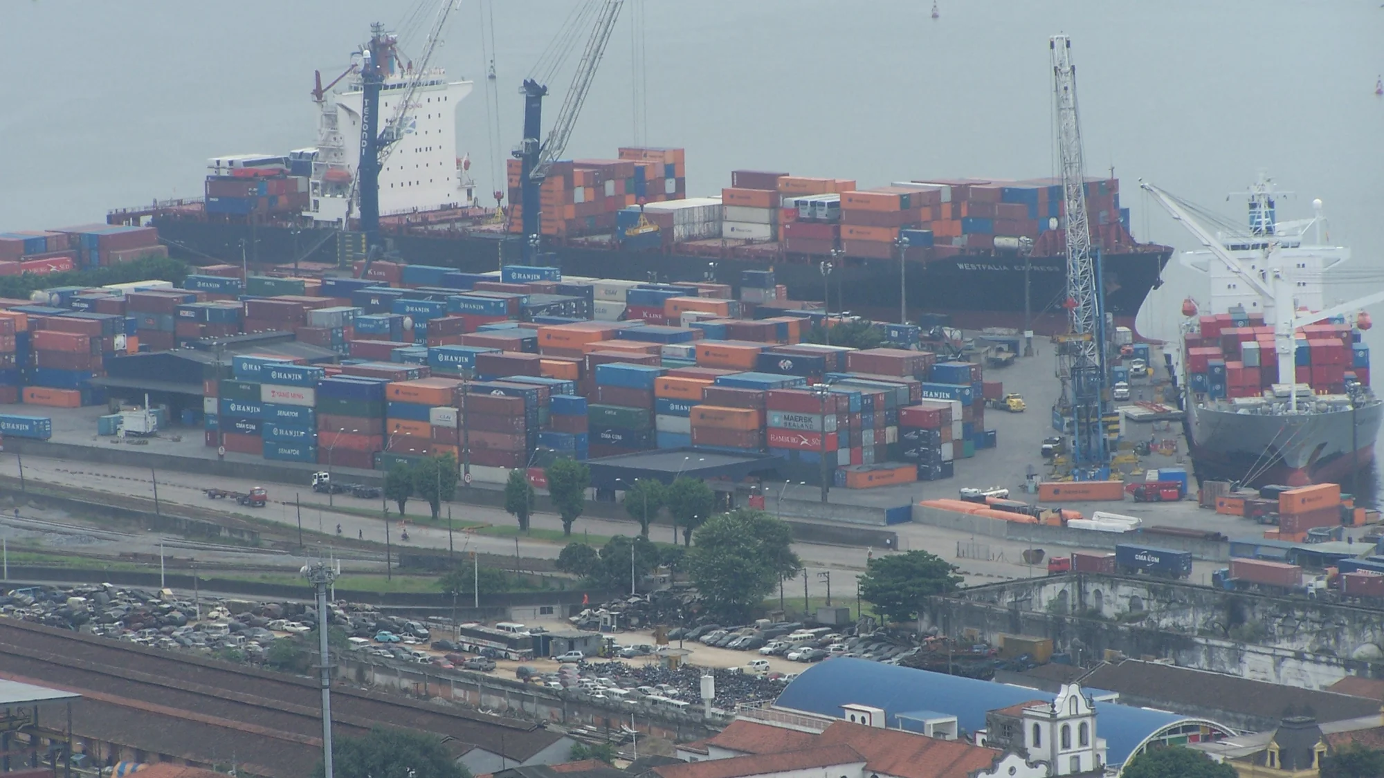 Container stacks, cargo vessels and quayside cranes at the Port of Santos, Brazil