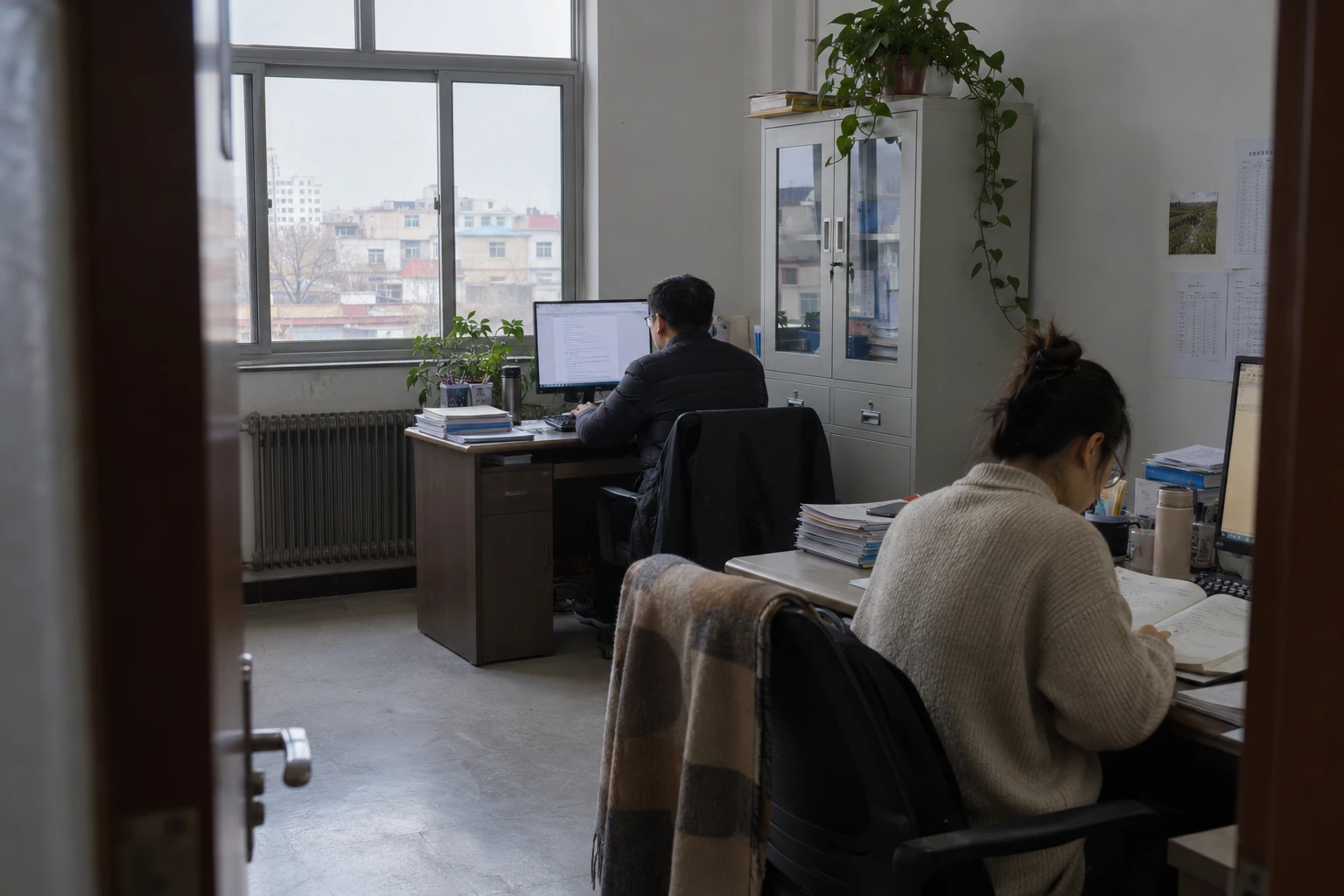 Two colleagues working at separate desks in an everyday office.